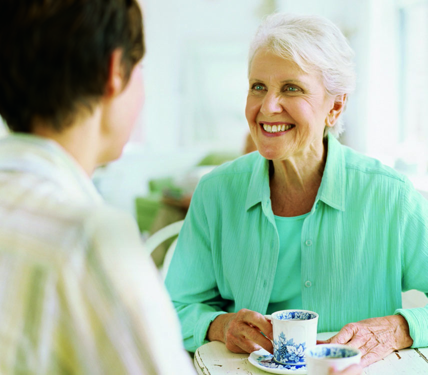 Two women talking to each other and drinking tea